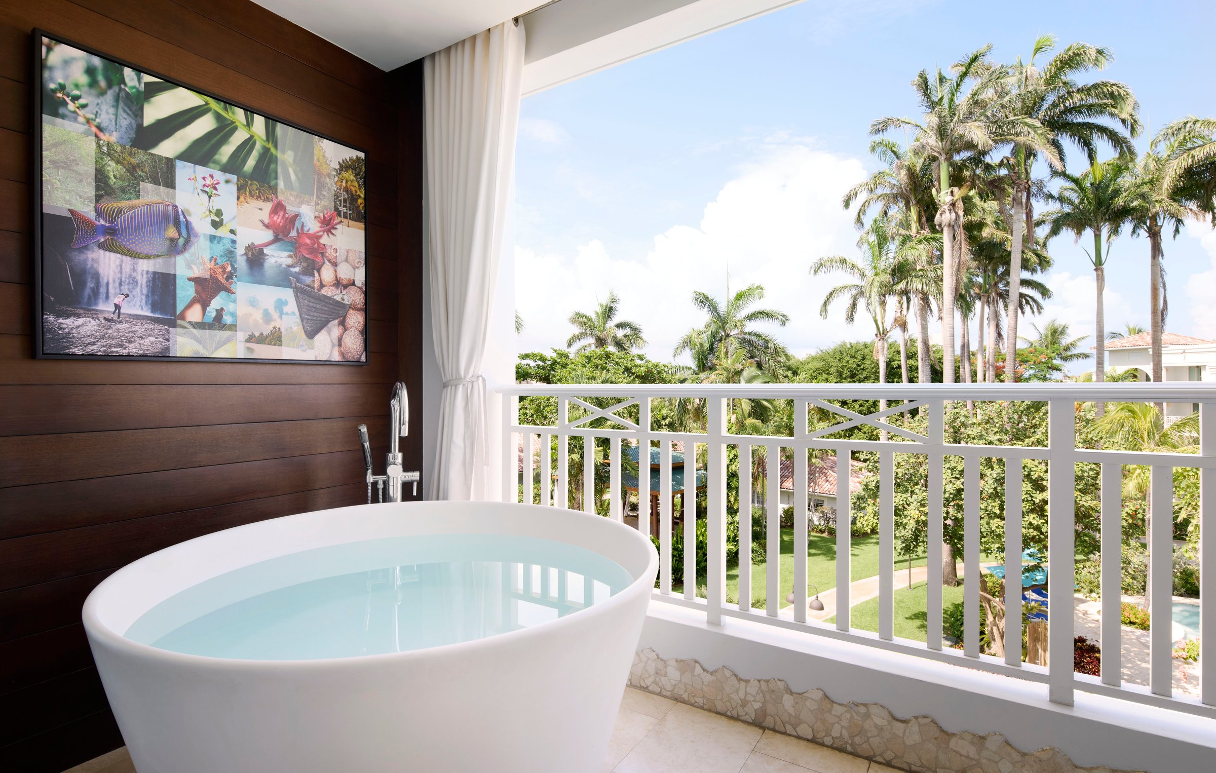 Balcony soaking tub overlooking royal palms and gardens.