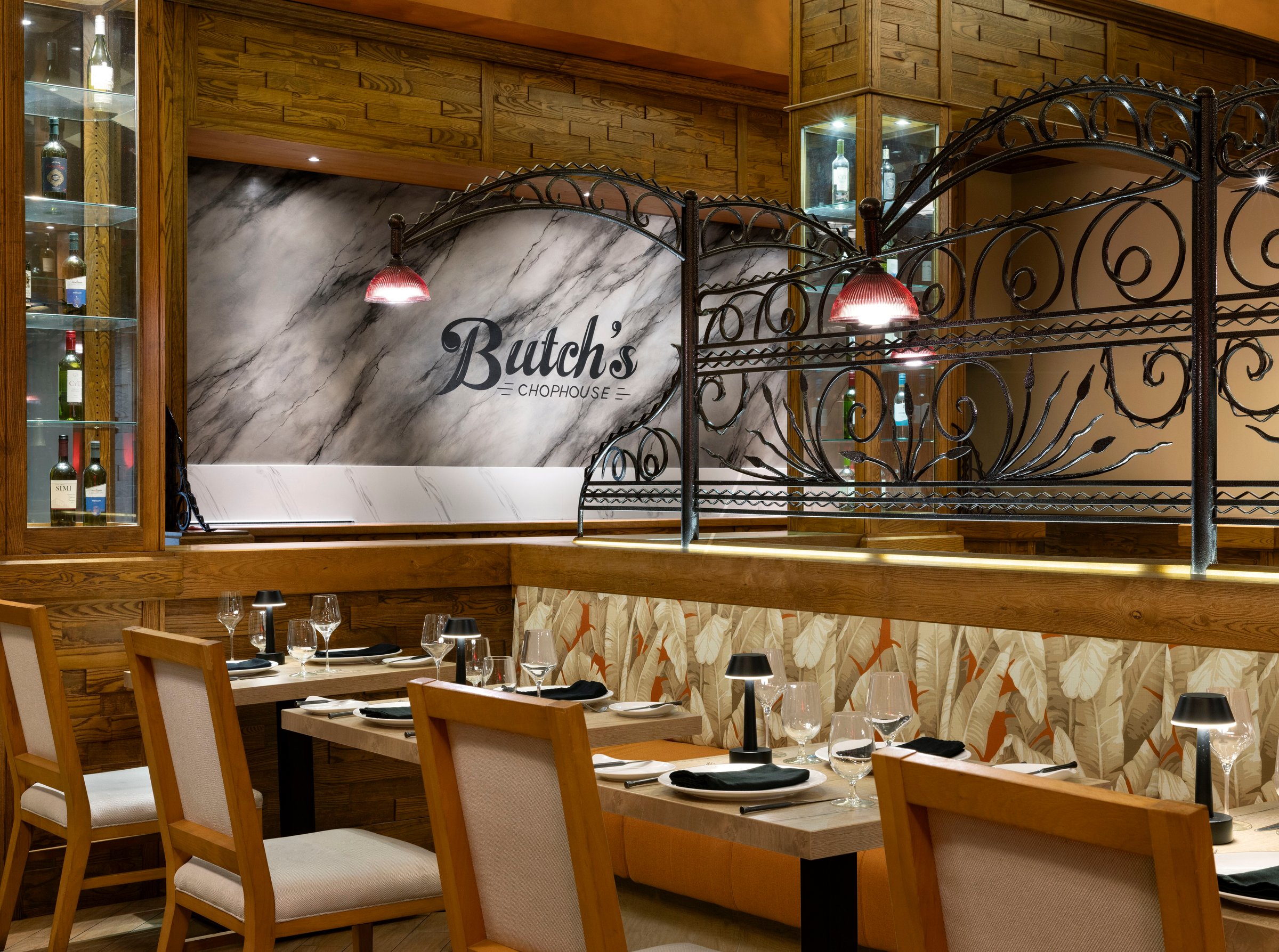 Butch's Chophouse dining room with marble wall and wrought-iron screen.