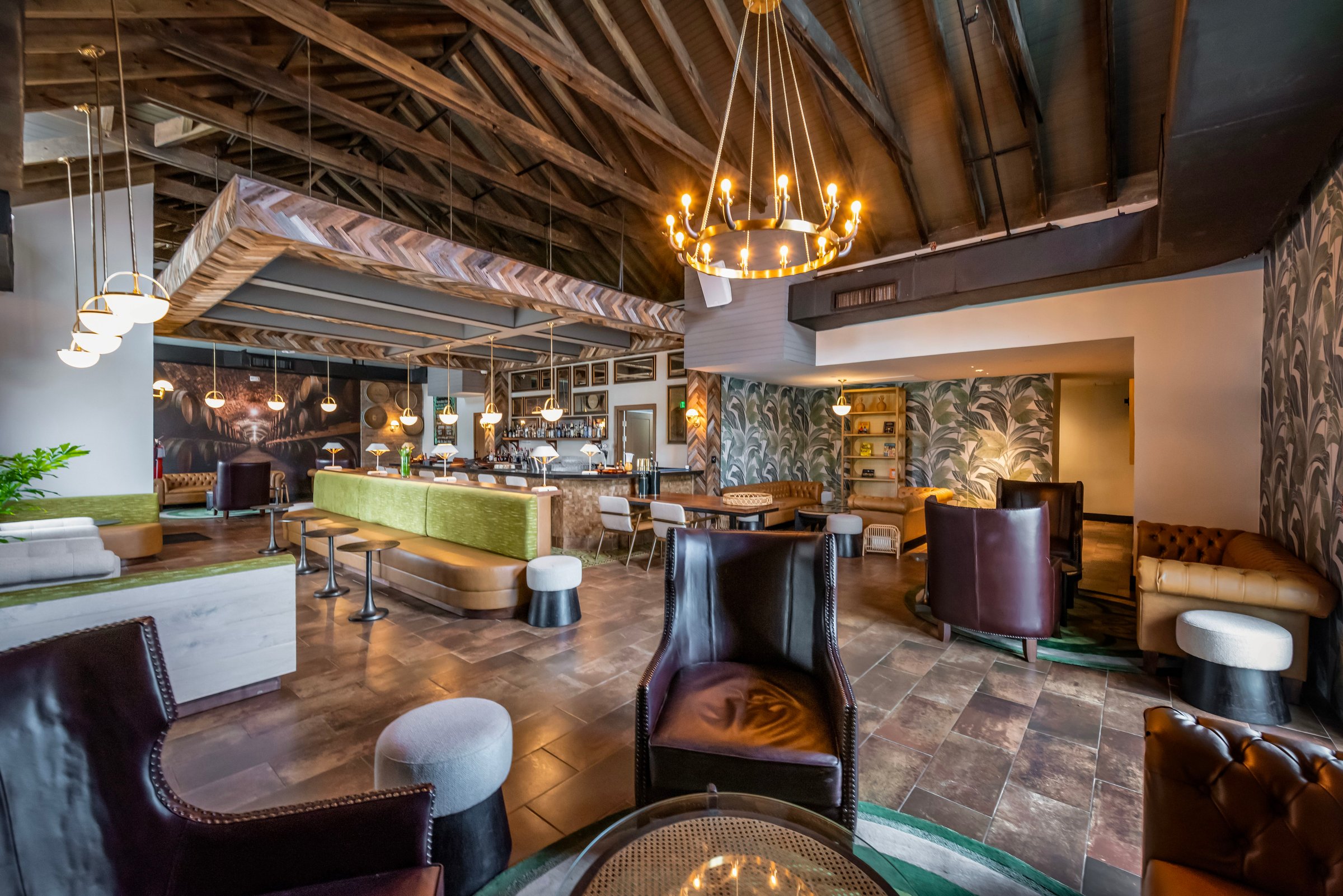 Dunn's Rum Club lounge with leather armchairs, chandeliers and palm-print walls.