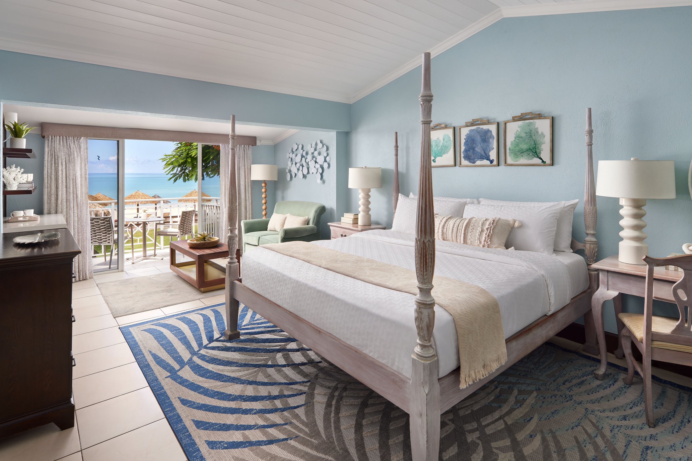 Beachfront room with a whitewashed four-poster bed opening onto the beach.