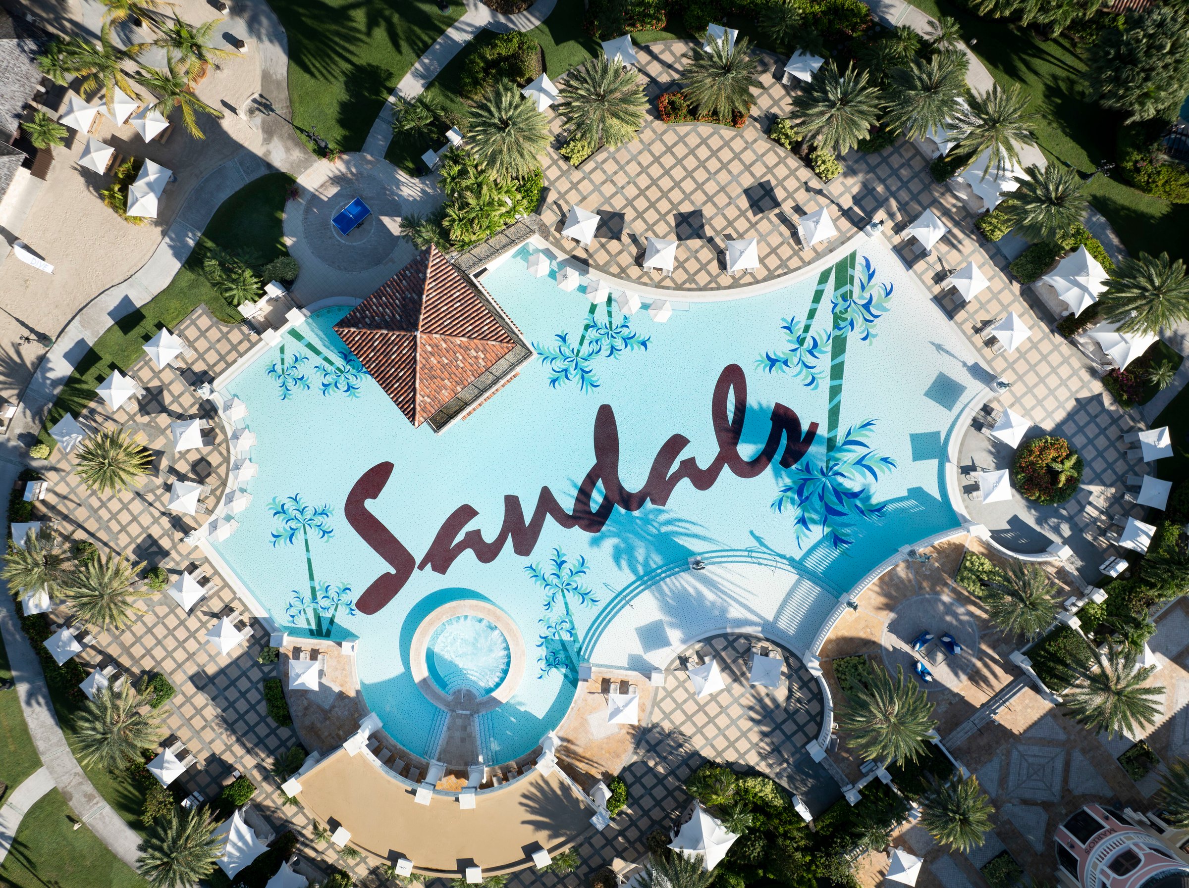 Top-down aerial of the Mediterranean pool with the Sandals mosaic and central gazebo.