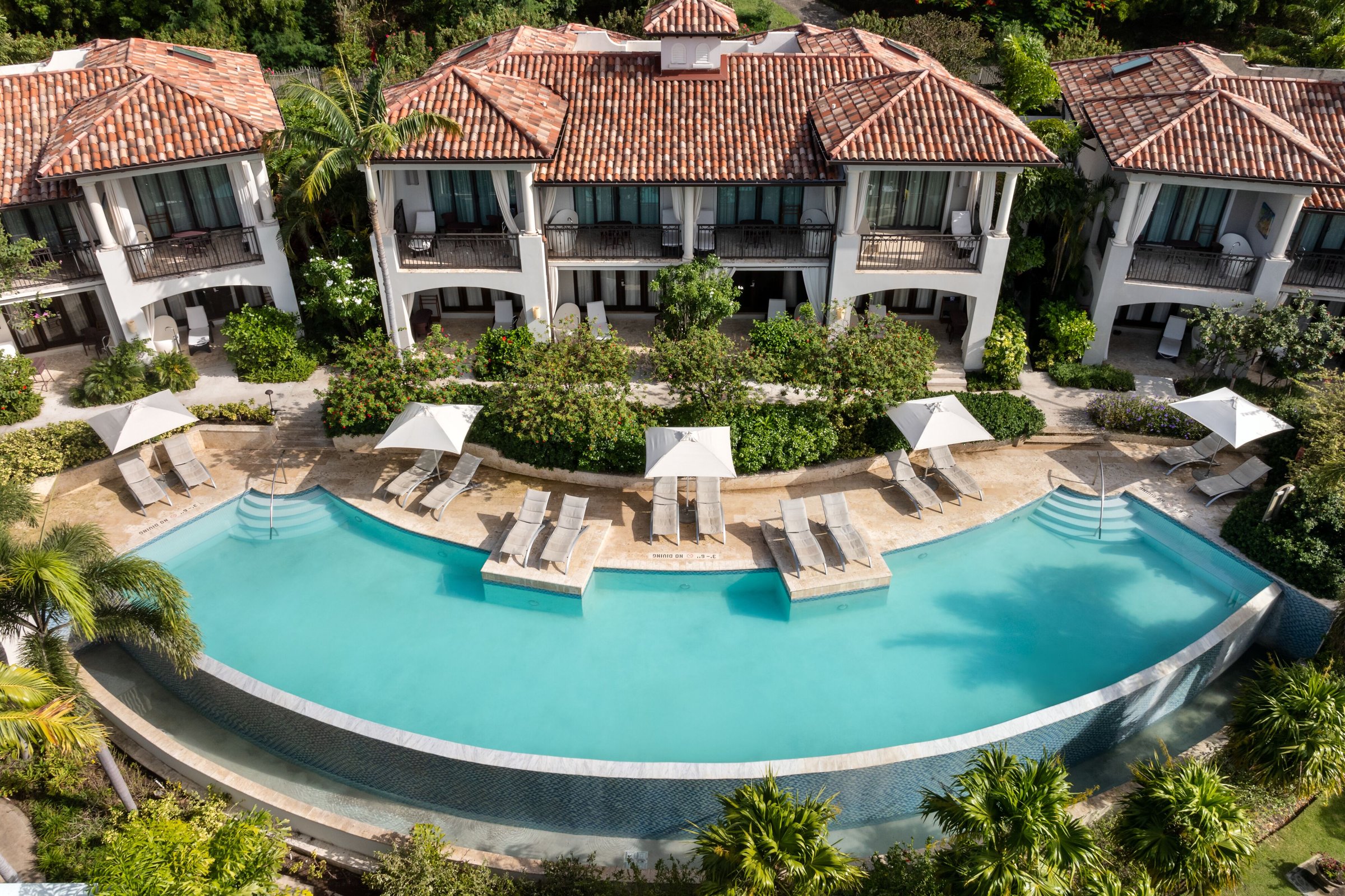 Serenity infinity pool with sun loungers below the villa suites.