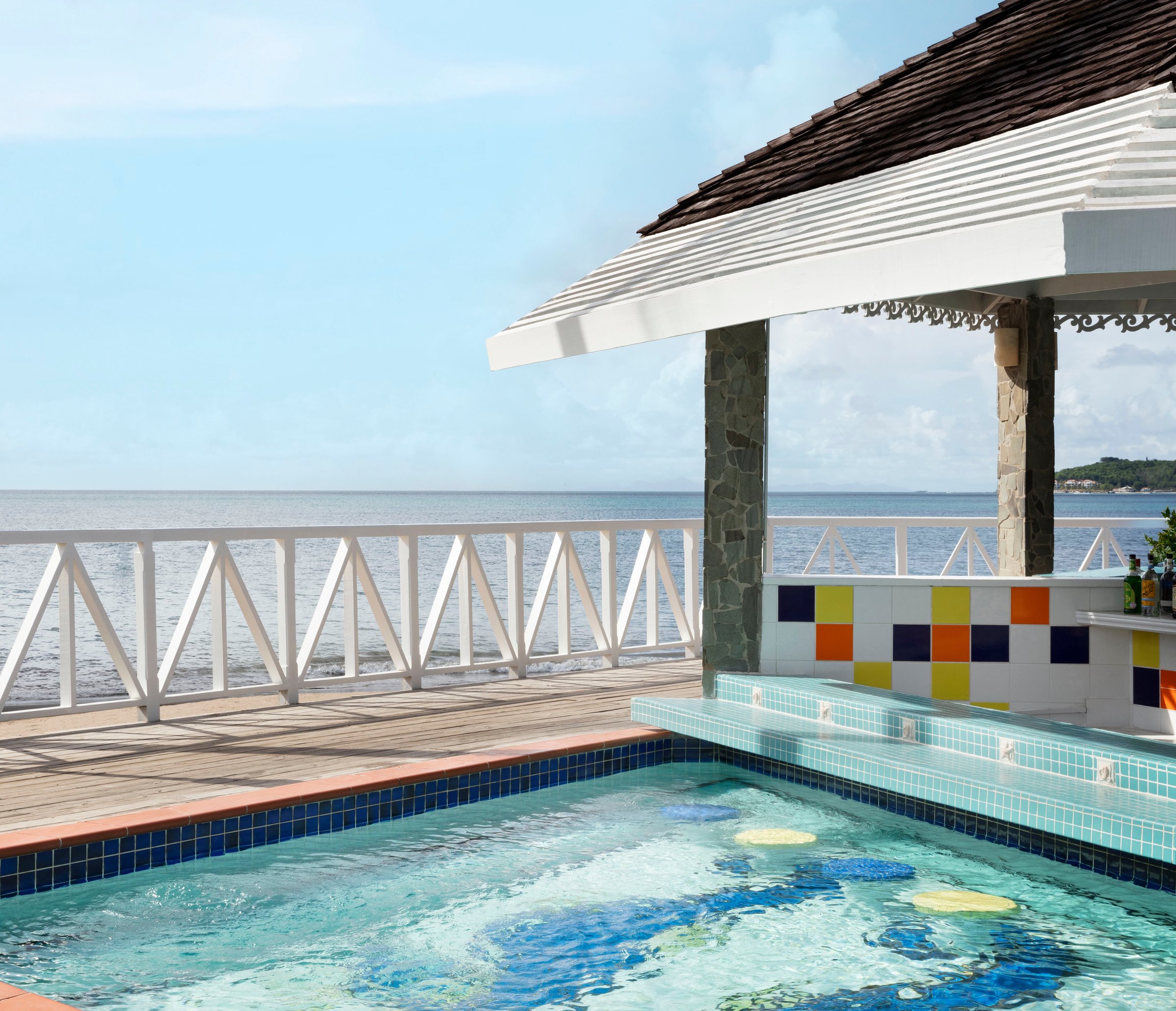 Seaside swim-up bar with colourful tiles and in-pool stools.