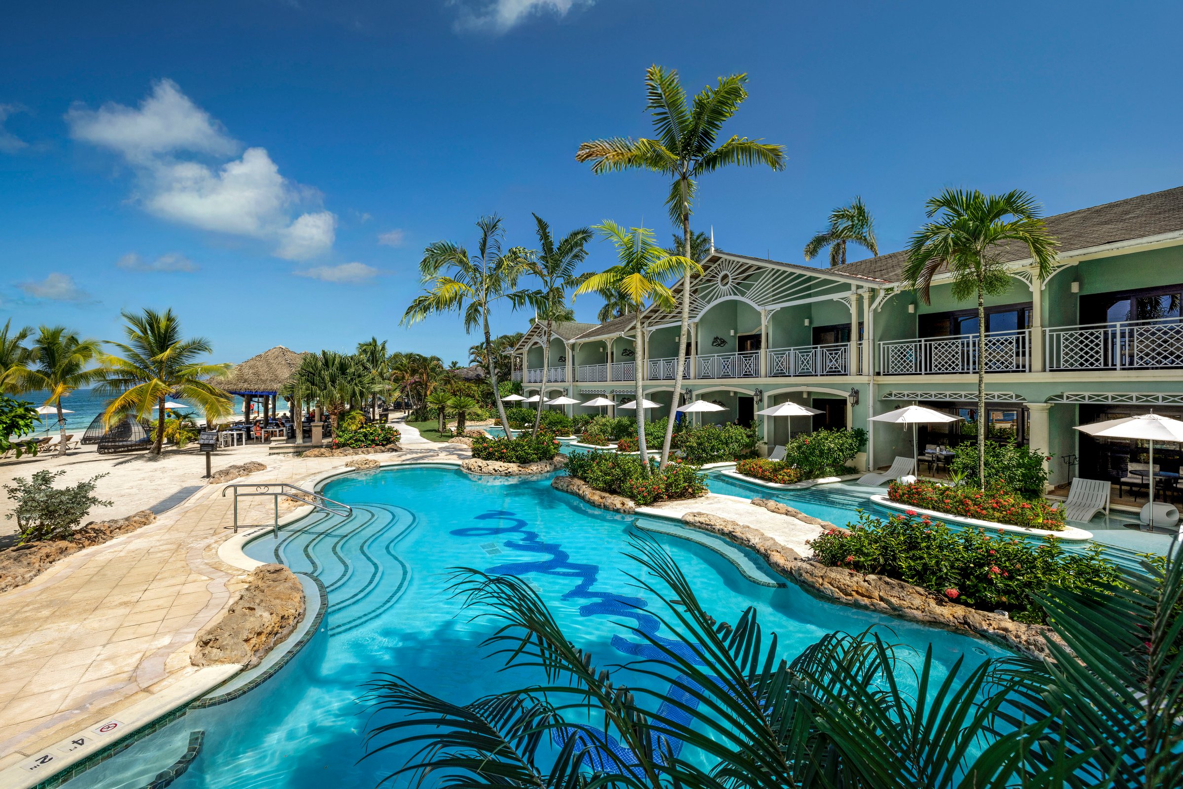 Crystal Lagoon pool winding past the swim-up suites and palms.