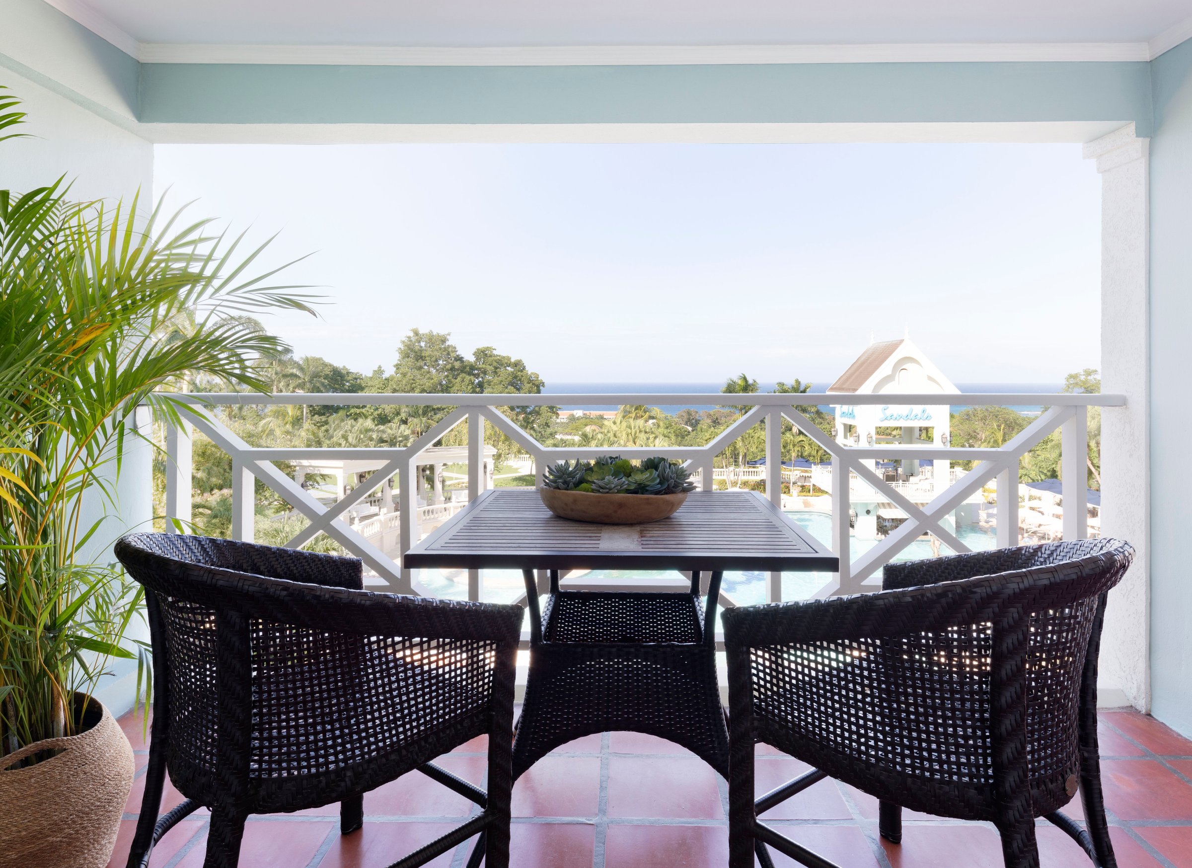 Balcony dining set looking over gardens toward the sea.
