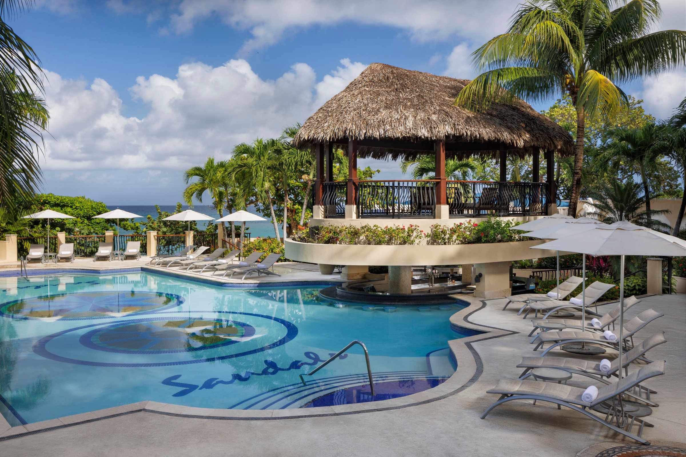 Riviera pool with the Sandals mosaic and a thatched bar gazebo.