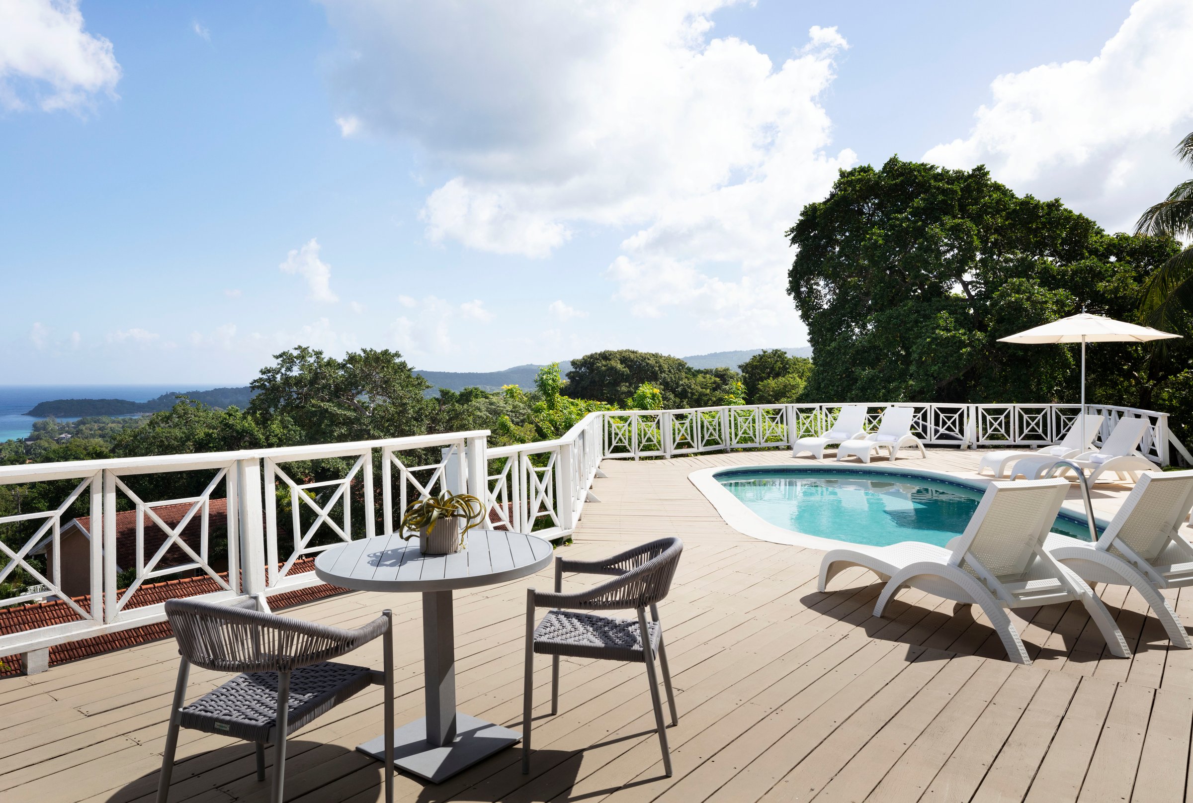 Suite deck with a private pool, loungers and hillside ocean view.