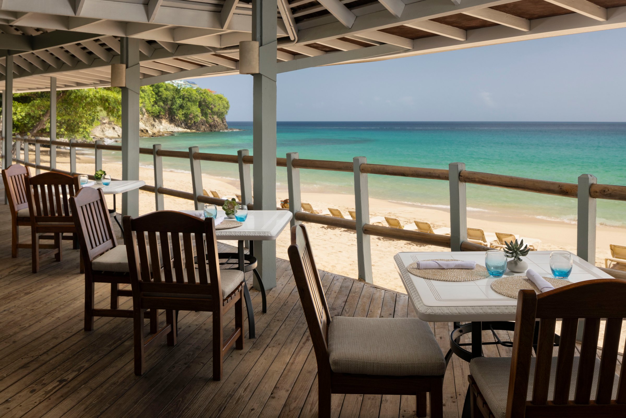 Neptune's beachfront deck dining with sea and sand views.