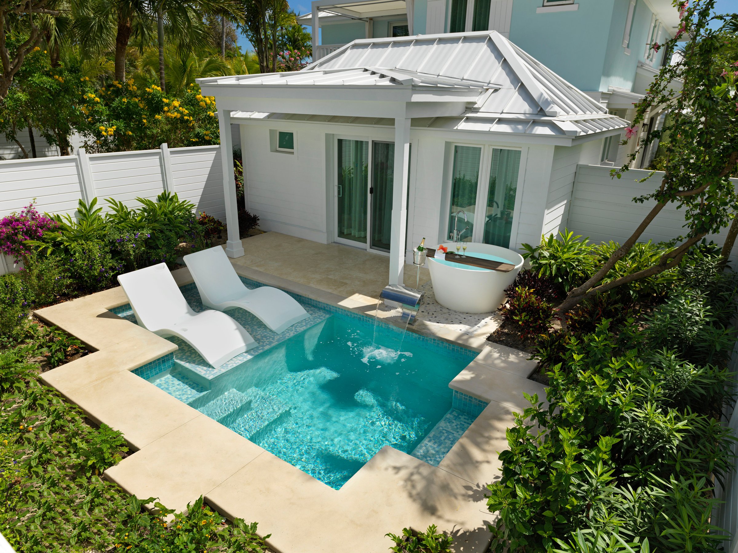 Private plunge pool with in-water loungers and a soaking tub at a villa suite.