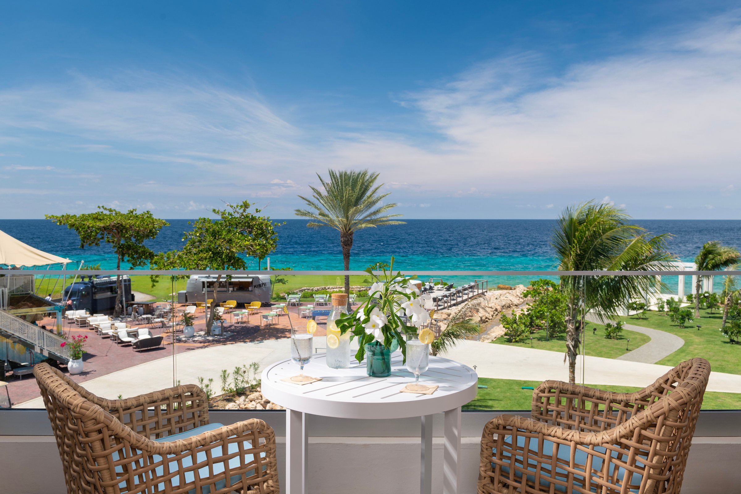 Balcony with wicker chairs overlooking the gardens and sea.