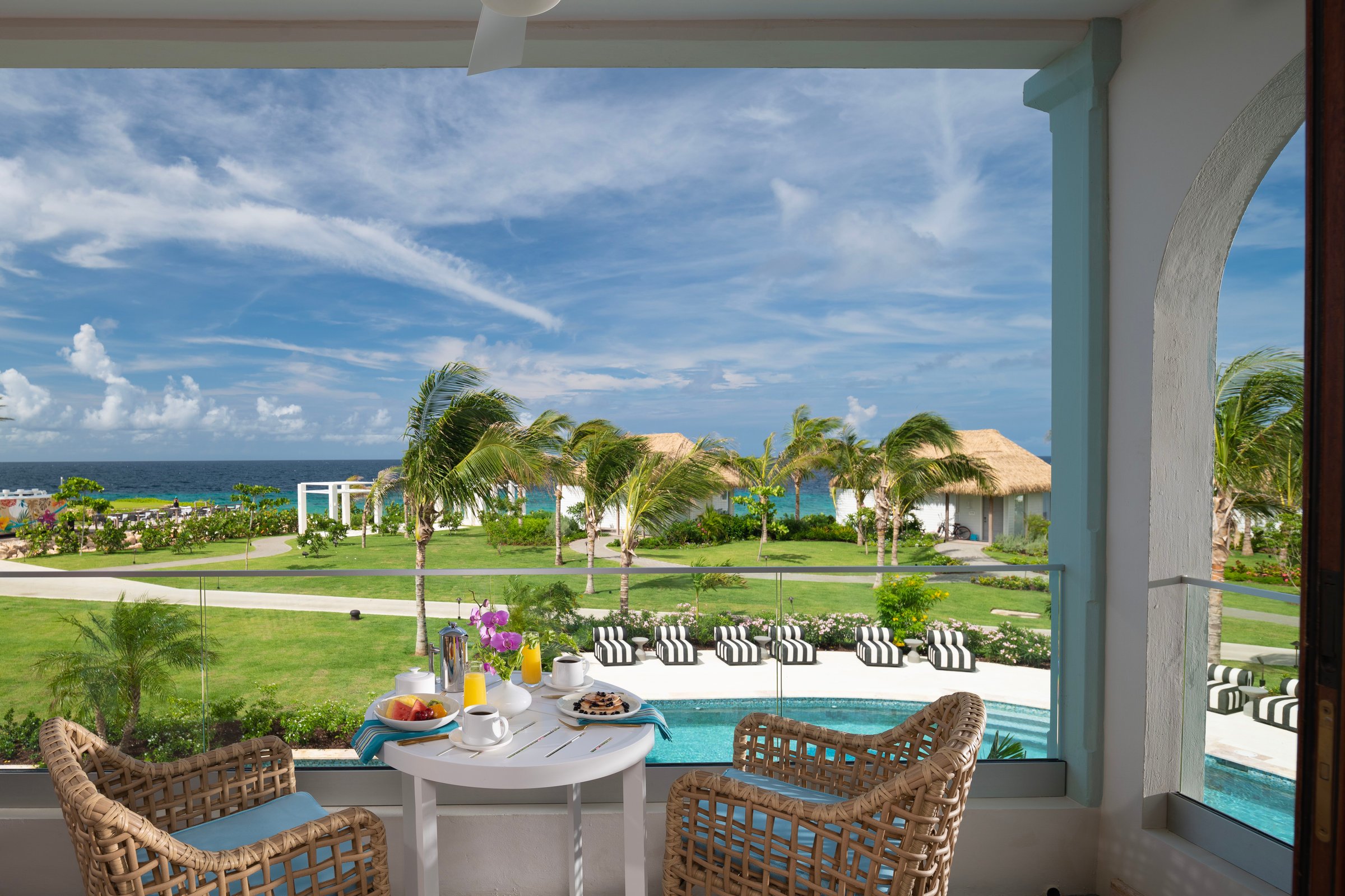 Balcony breakfast table overlooking gardens, pool and sea.