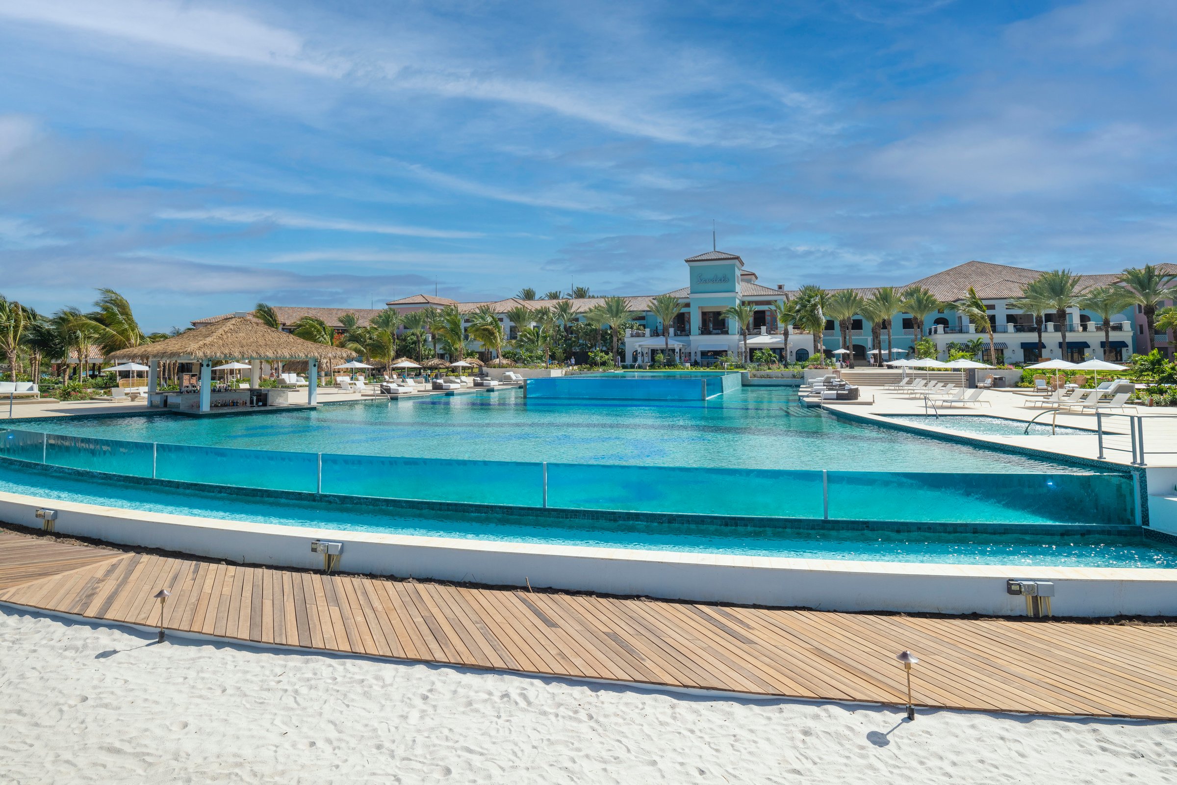 Glass-edged infinity pool beside the beach boardwalk.