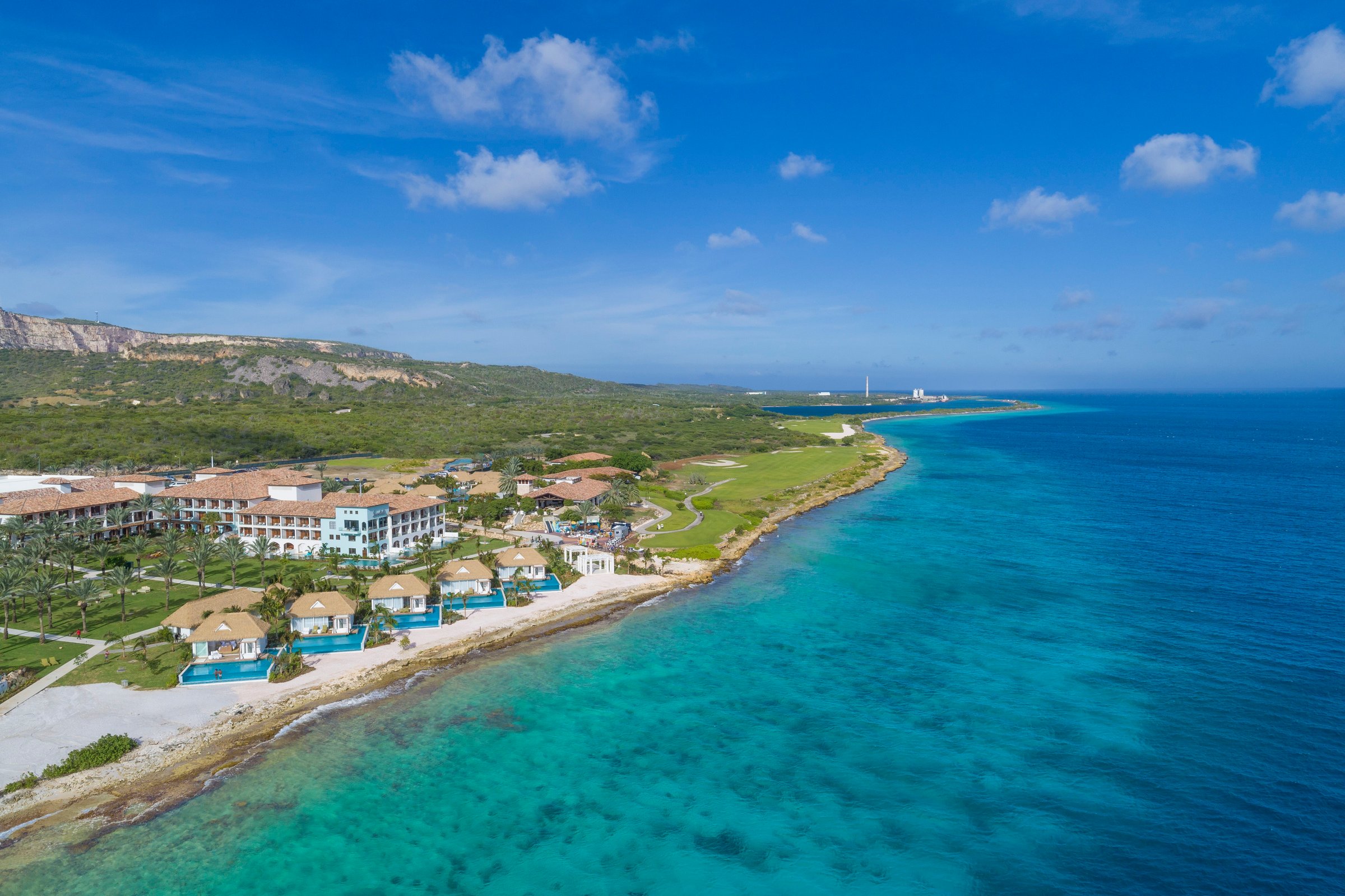 Aerial of the resort and beachfront villas along the turquoise coast.