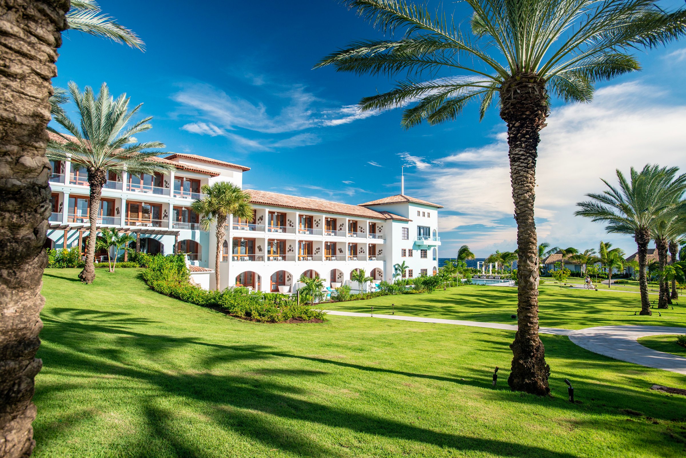 White room blocks above sweeping lawns and palms.