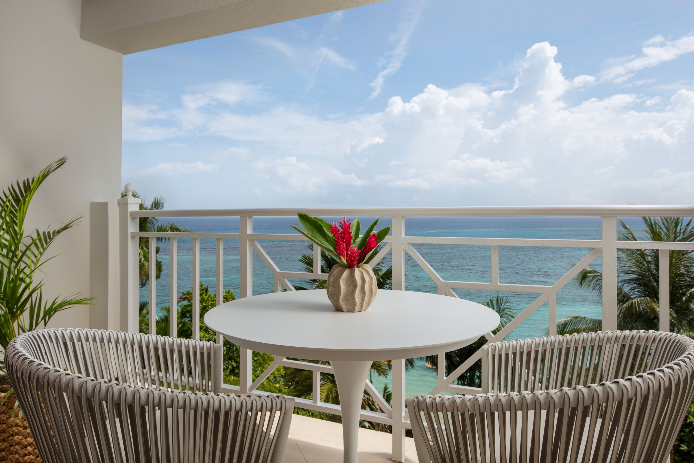 Suite terrace table with red ginger flowers overlooking the sea.