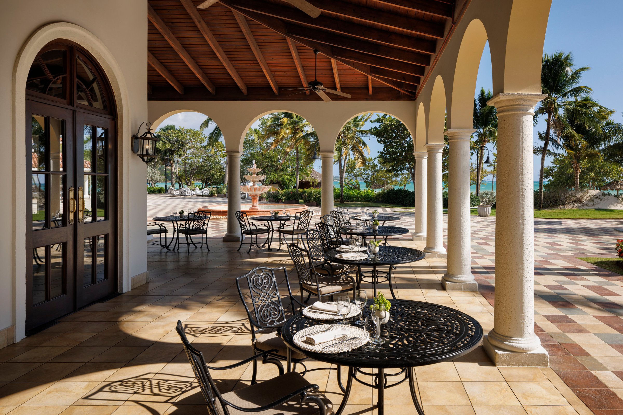 Arched colonnade terrace dining with wrought-iron tables.