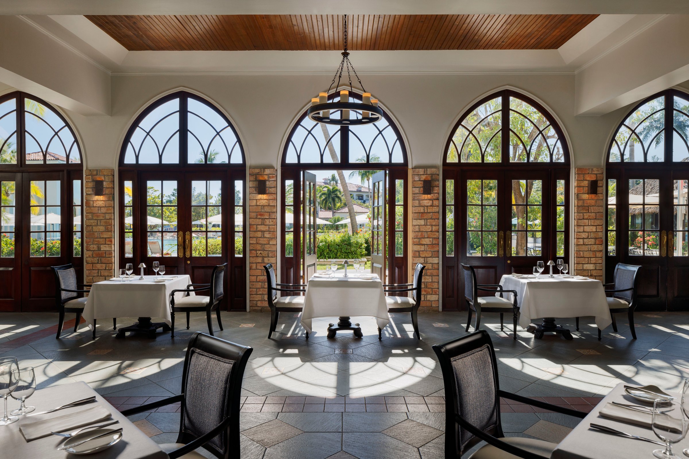 Eleanor's dining room with tall arched windows and a wrought-iron chandelier.
