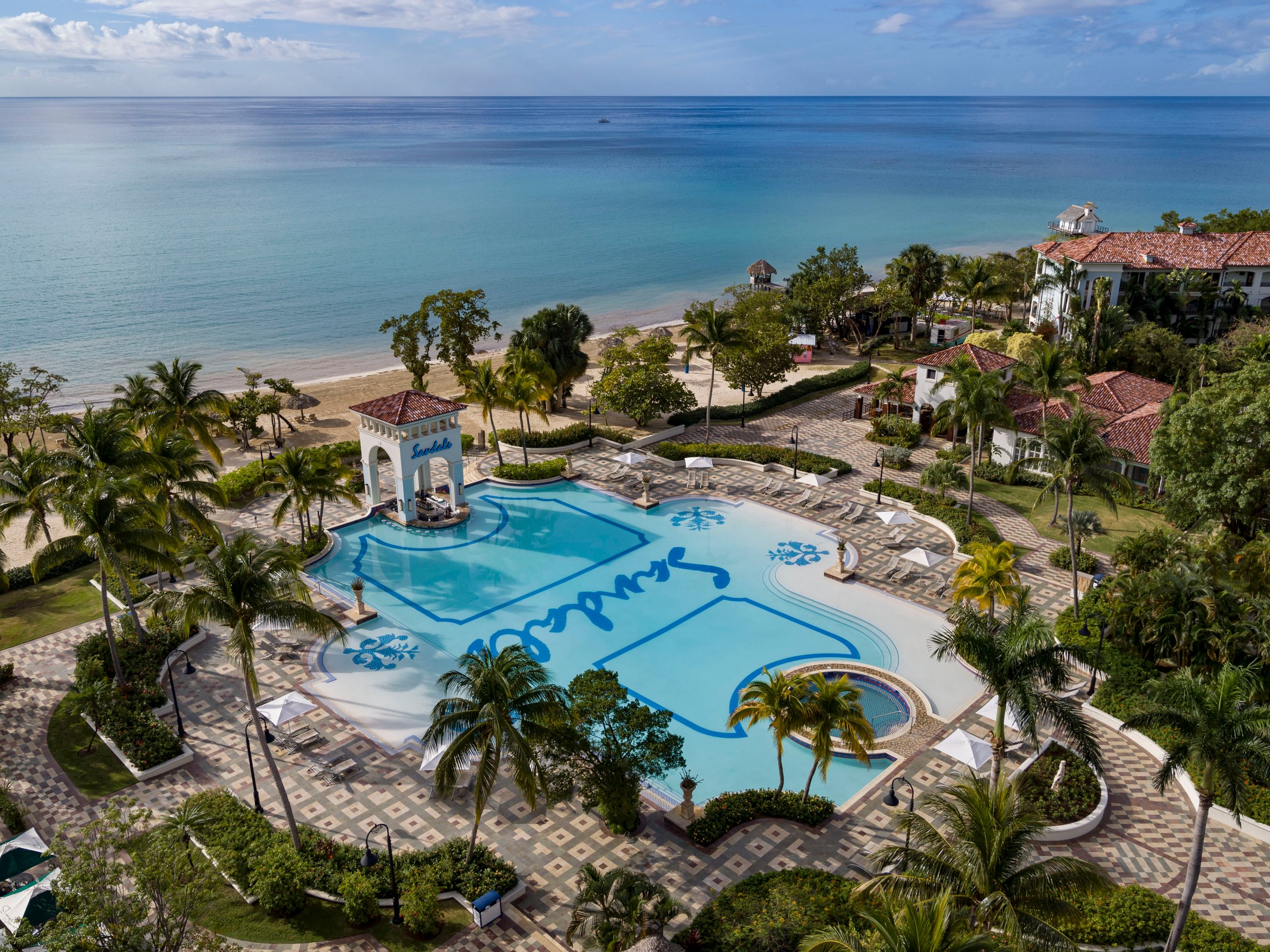Elevated view of the main pool with Sandals mosaic, gazebo and beach.