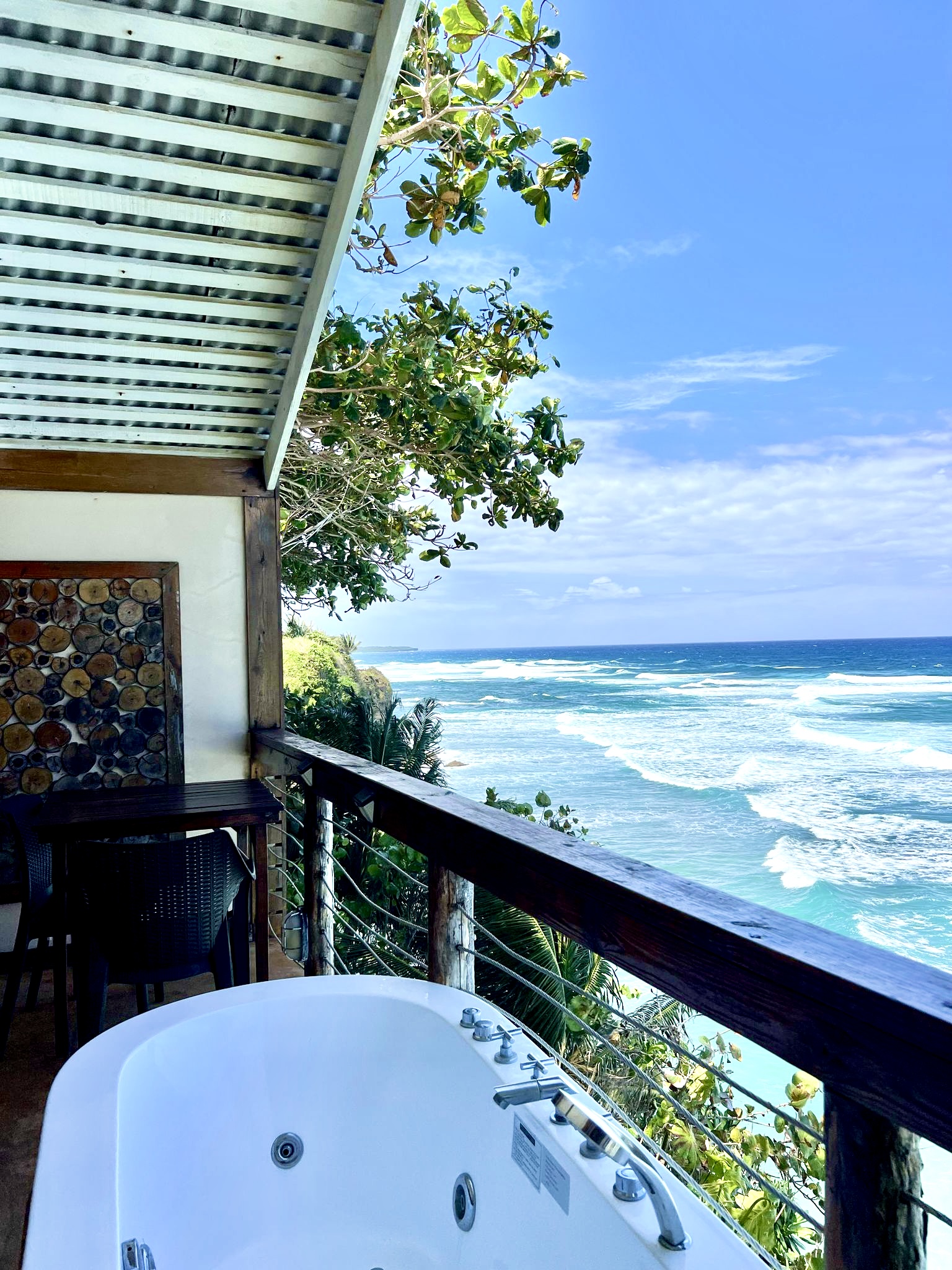 Outdoor bathtub on a clifftop deck overlooks the ocean and breaking waves at Sea Cliff Resort & Spa.