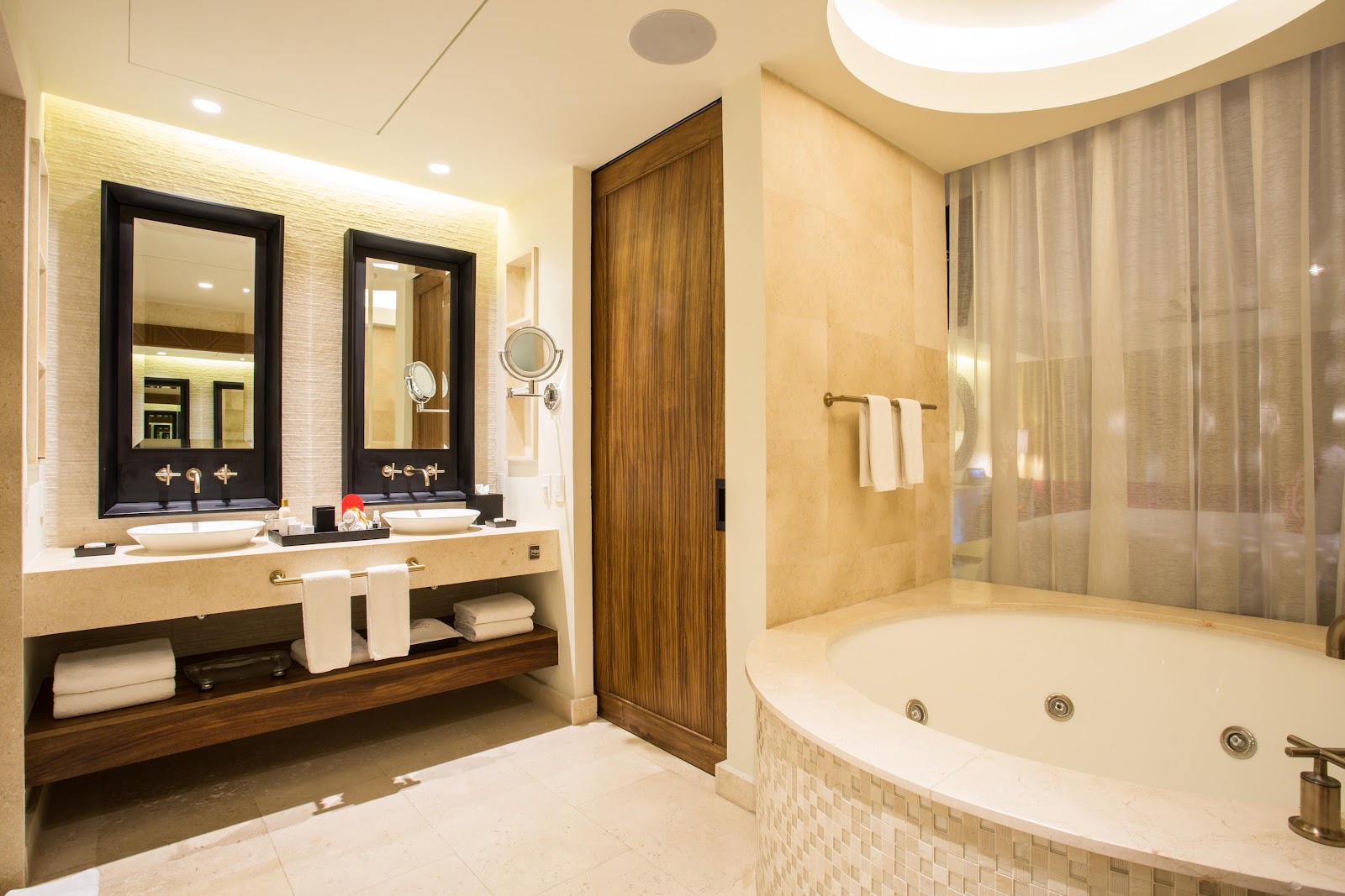 Bathroom with dual vanities, framed mirrors, and a sunken soaking tub with jets at Secrets Akumal Riviera Maya.
