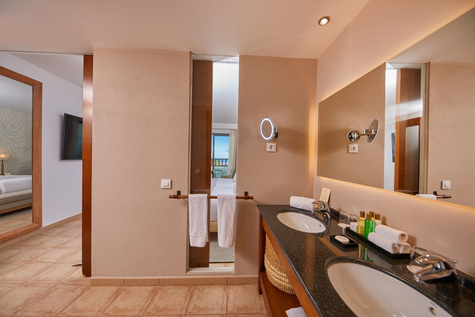 Bathroom with double sink, dark countertop, large mirror, and walk-in shower with glass enclosure at Secrets Lanzarote Resort & Spa.