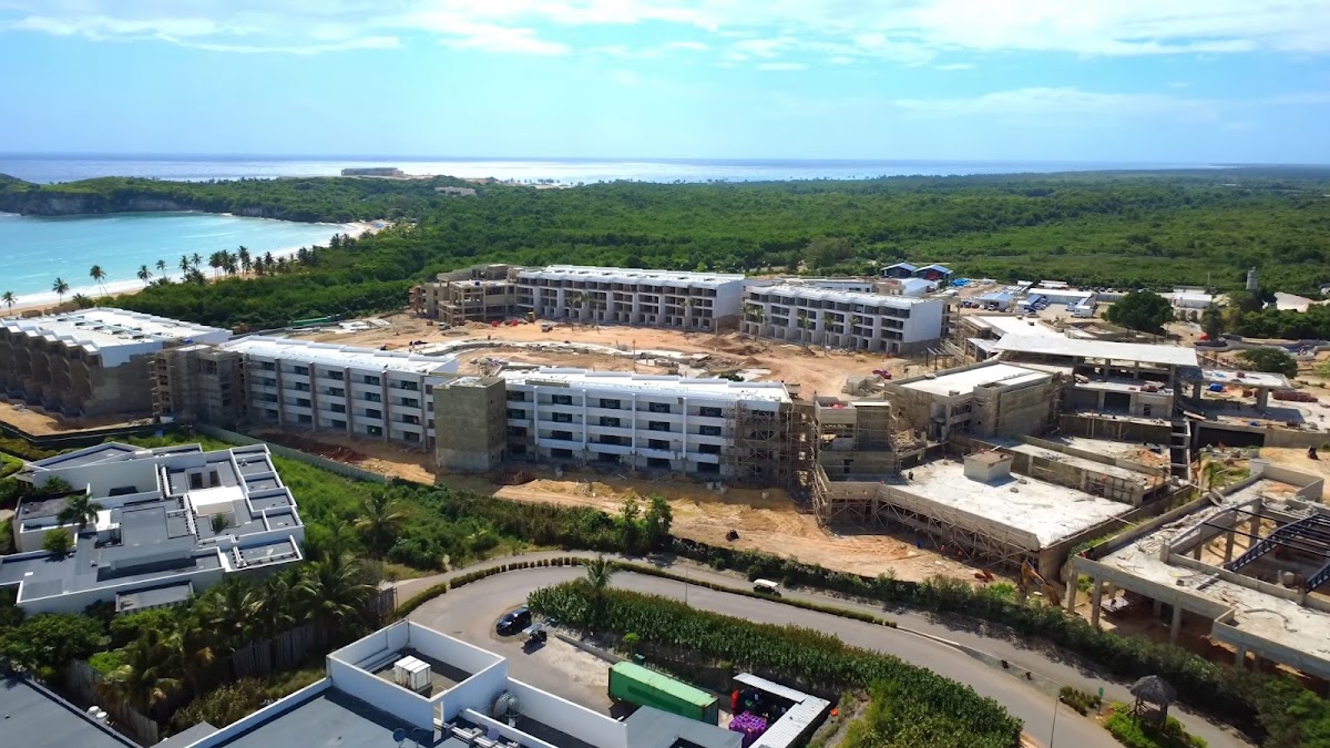 Aerial view of Secrets Macao Beach Punta Cana resort under construction, with turquoise lagoon and tropical forest in background.