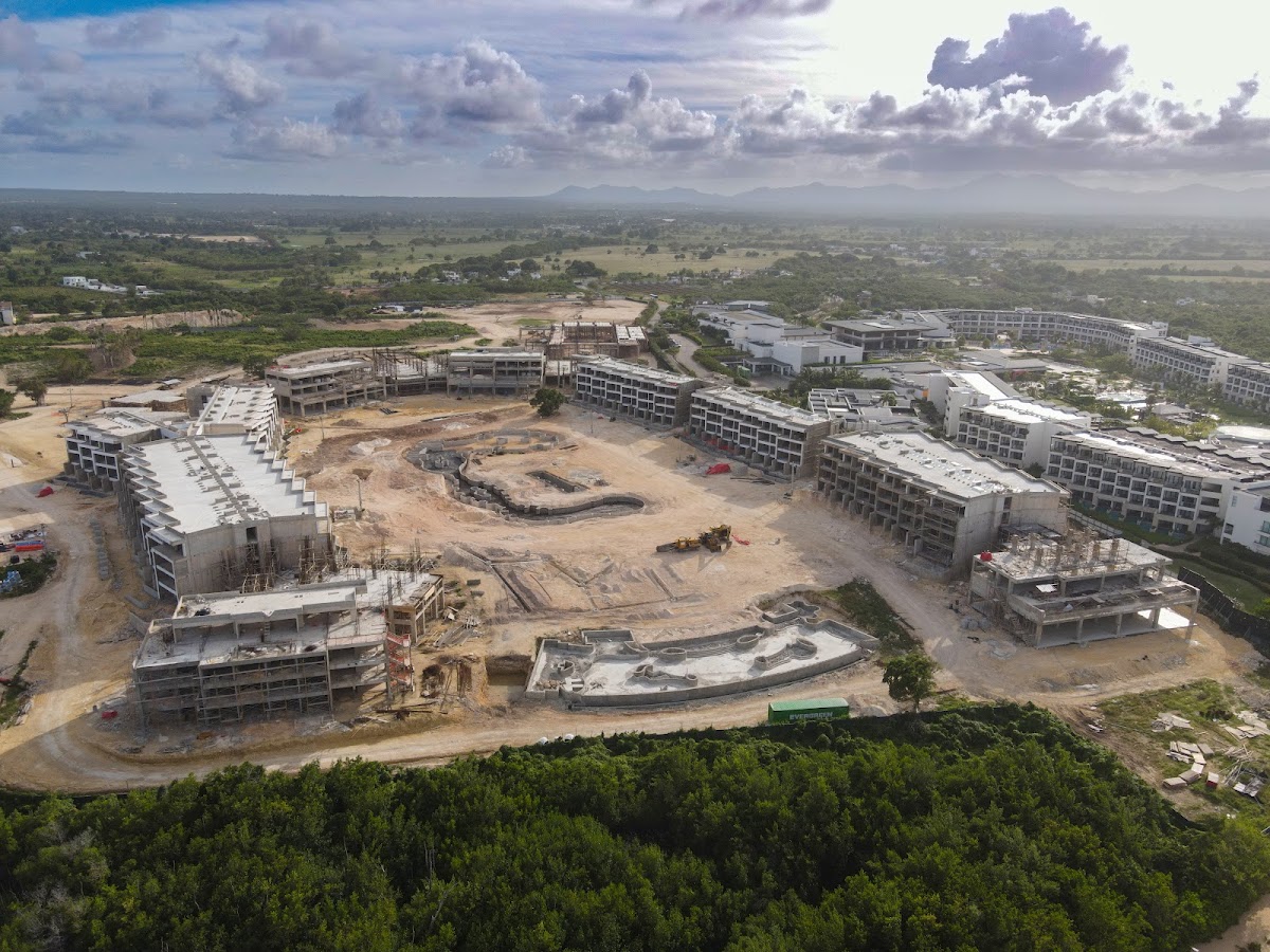 Aerial view of Secrets Macao Beach Punta Cana construction site with multiple white buildings under development surrounded by cleared land and tropical vegetation.