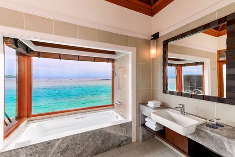 Bathroom with soaking tub featuring panoramic ocean view at Sheraton Maldives Full Moon Resort & Spa, along with vanity and mirror.