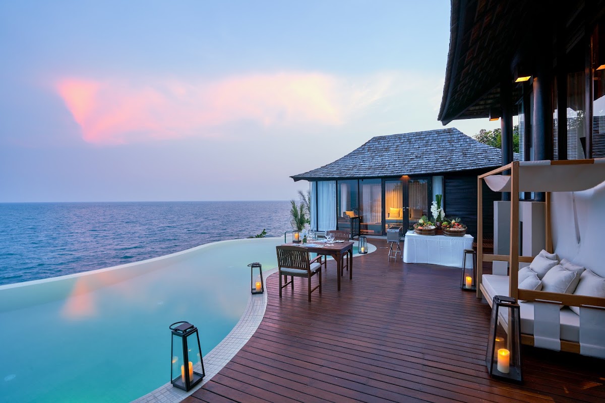 Overwater villa at Silavadee Pool Spa Resort with private pool, dining area, and ocean view at sunset.