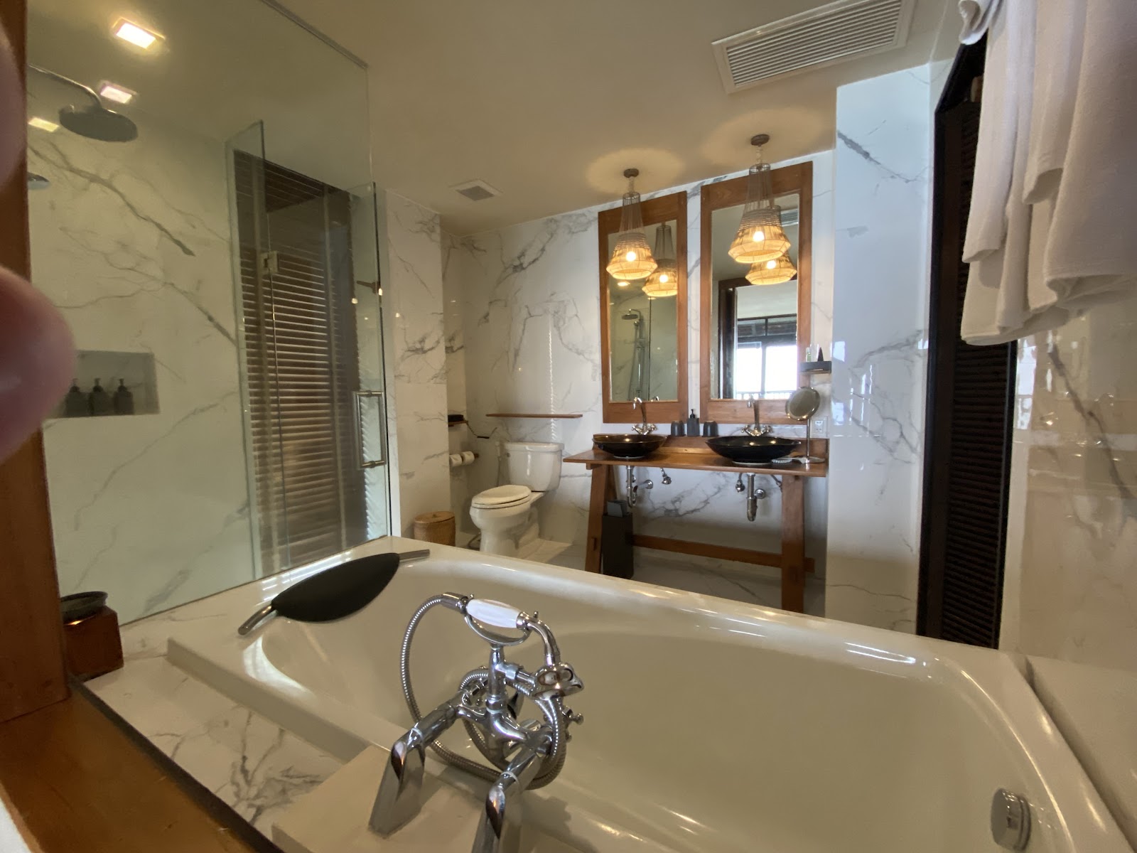 Marble-tiled bathroom with soaking tub, dual vanity sinks, glass shower enclosure, and pendant lighting at Silavadee Pool Spa Resort.