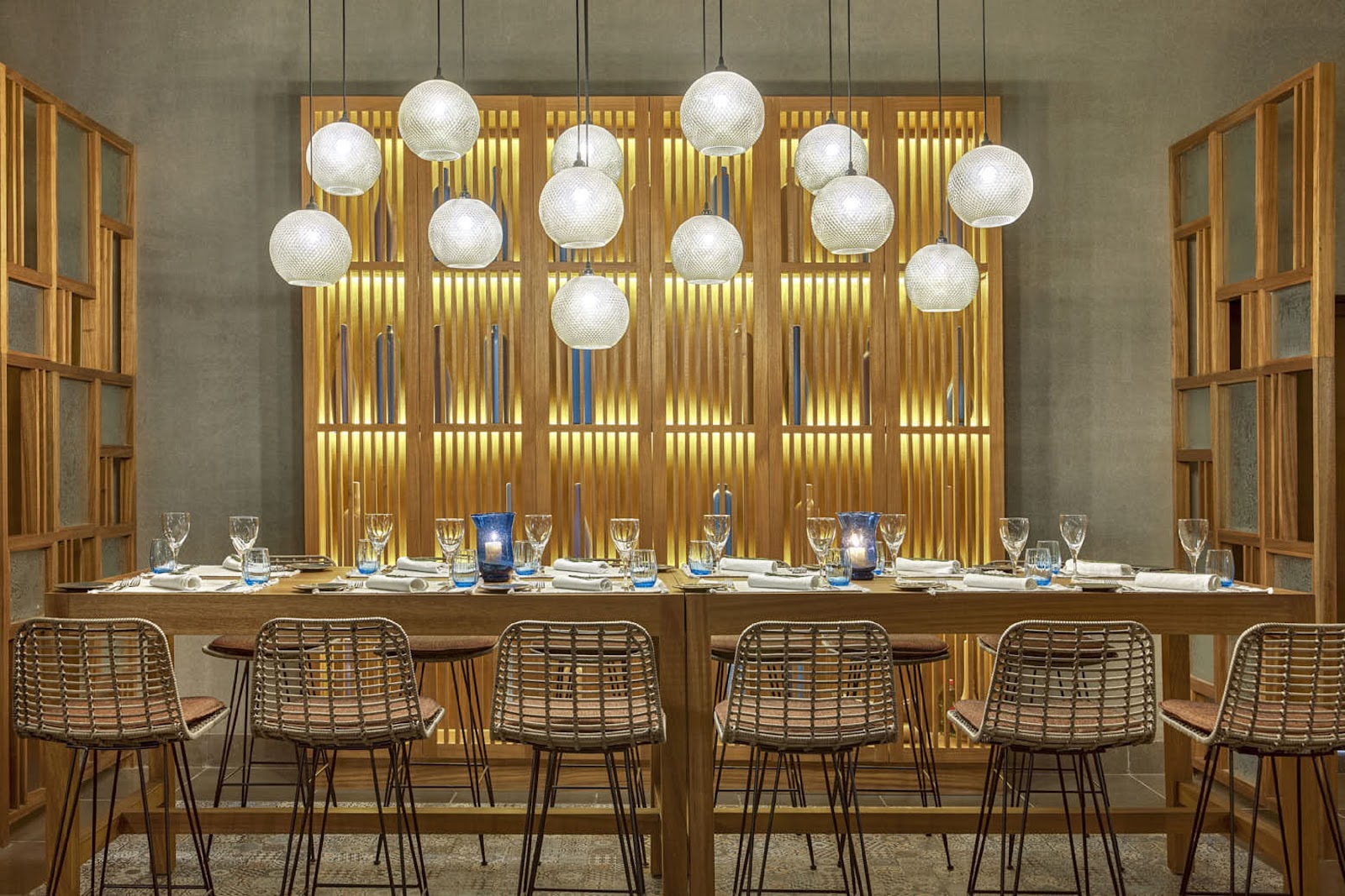 Dining room at Steigenberger Resort Alaya Marsa Alam with brick walls, wooden shelving, pendant lights, and tables set for service.