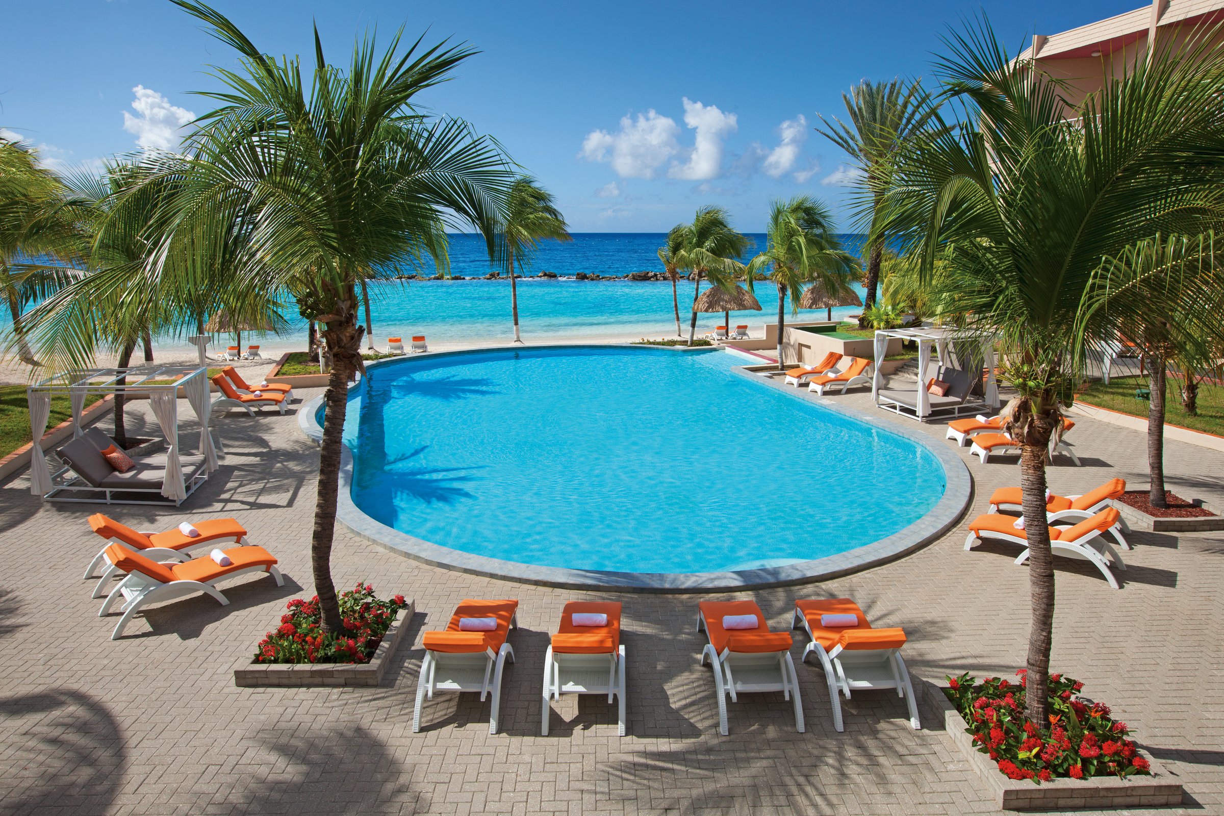 Sun Club circular pool with loungers and cabanas