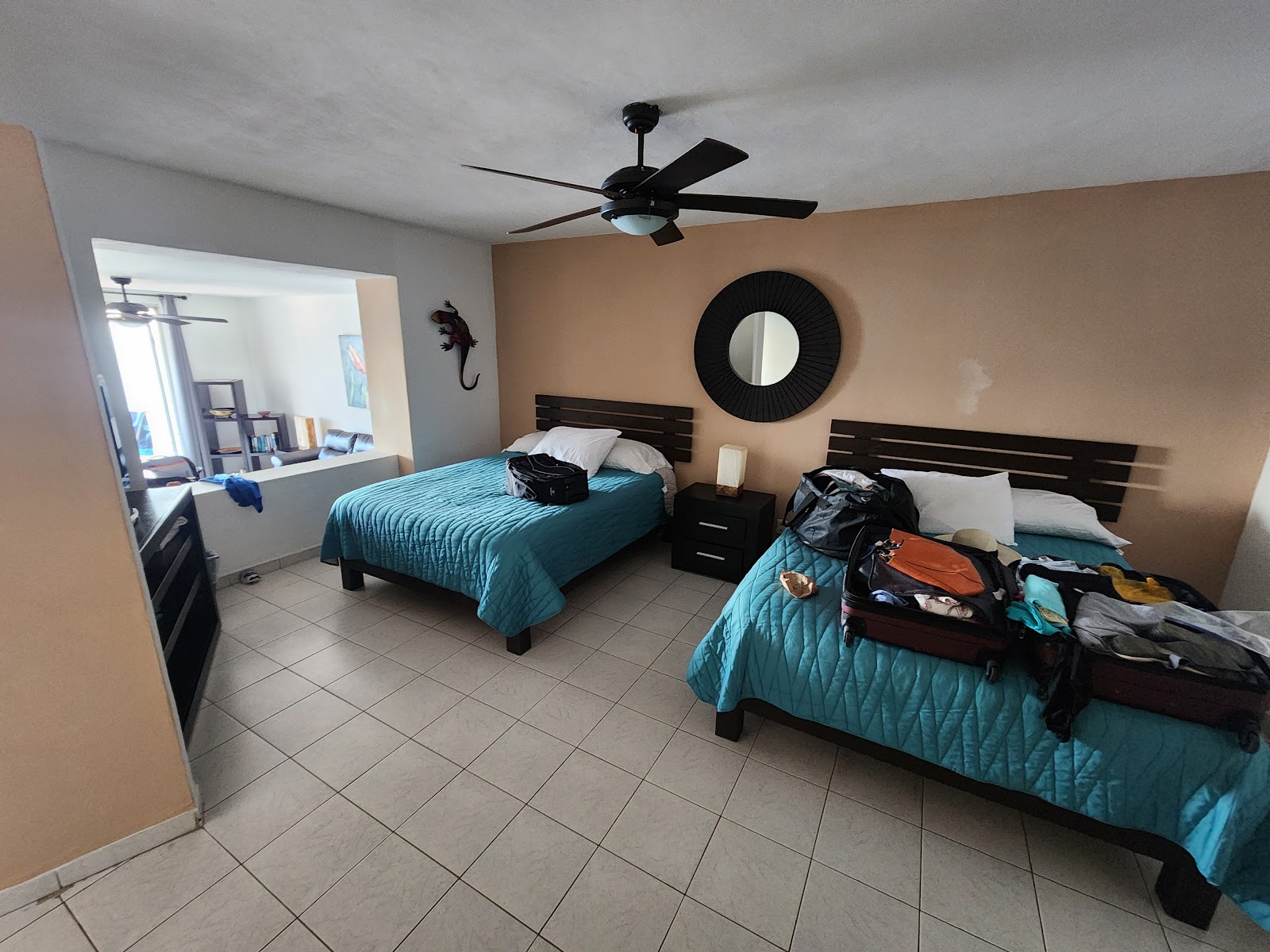 Sunscape Puerto Vallarta Resort & Spa bedroom with ocean view through sliding glass doors, potted plants on balcony, and blue bedding in foreground.