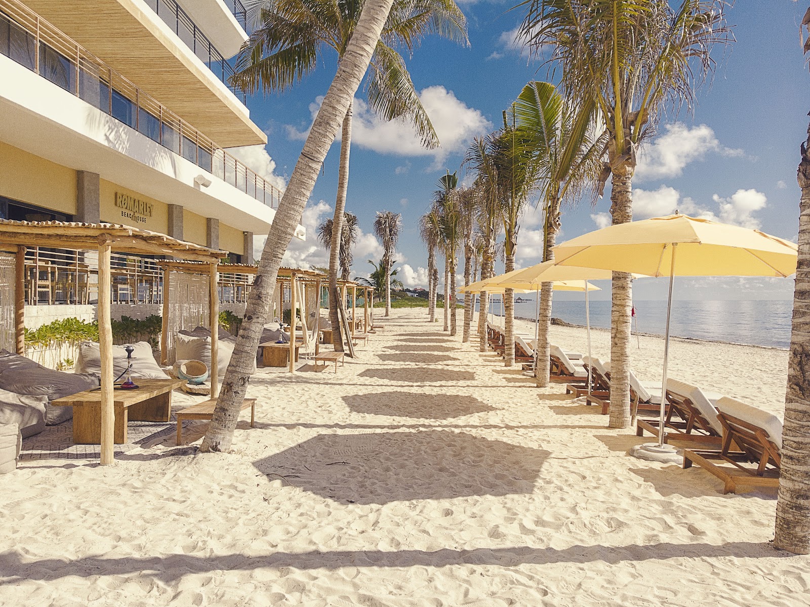 Private balcony with loungers and black chairs overlooking turquoise ocean water and clear sky at The Fives Oceanfront Riviera Maya.