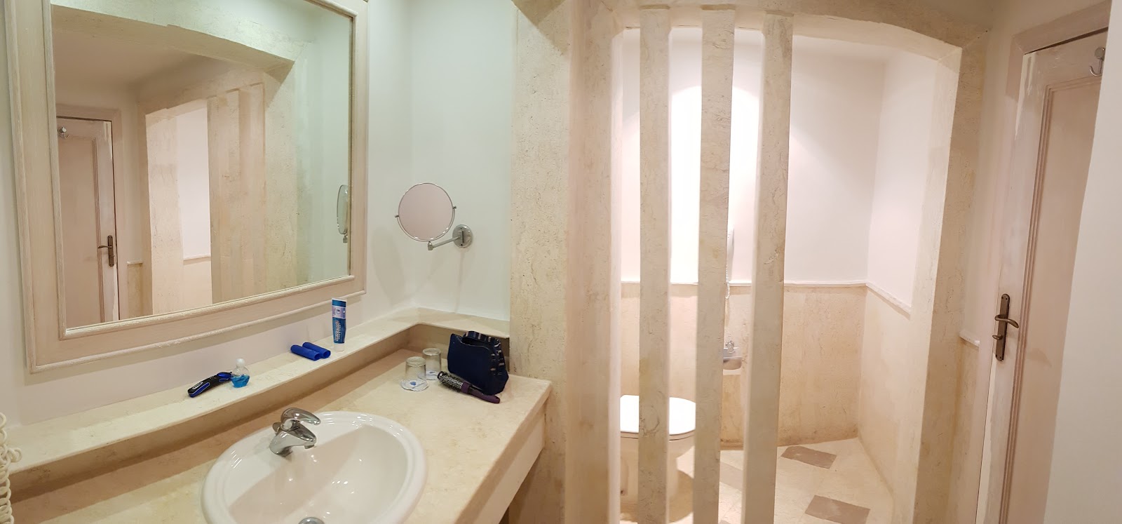 Bathroom with marble countertop, round sink, large mirror, and glass-enclosed shower at The Grand Hotel Sharm El Sheikh.