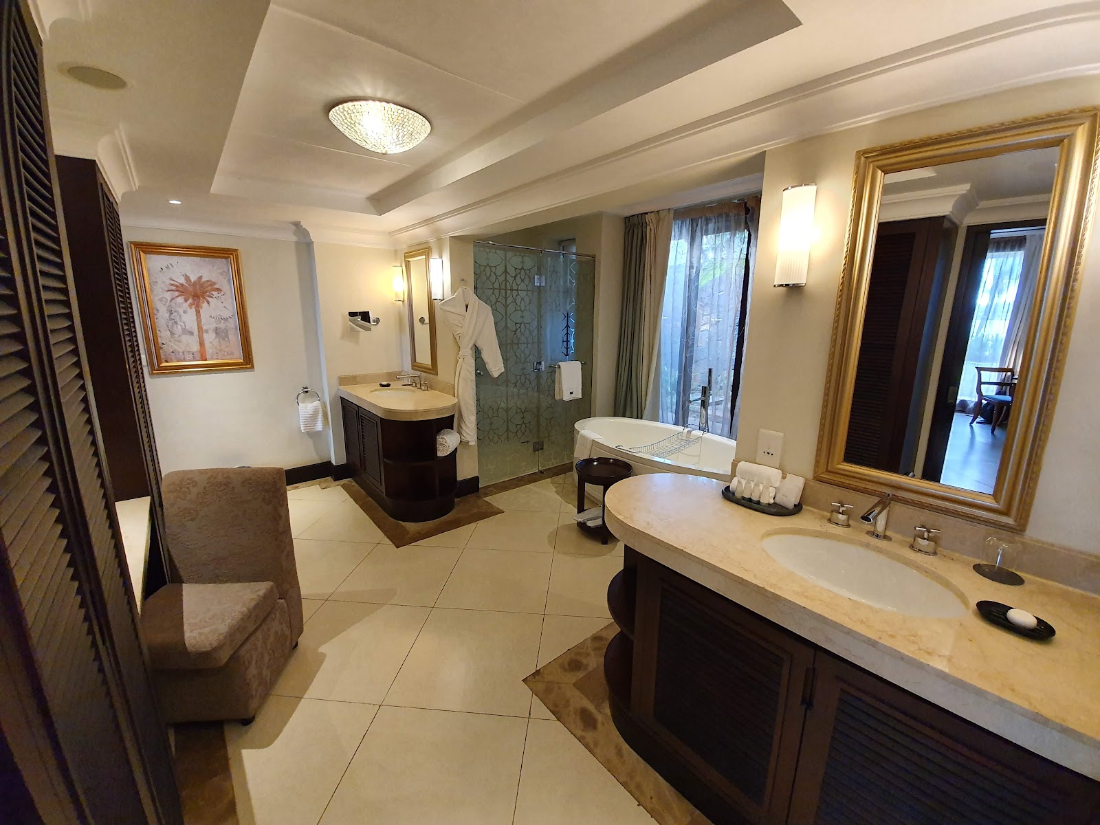 Spacious bathroom at The Westin Turtle Bay Resort & Spa with double vanity, walk-in shower, soaking tub, and cream tile flooring.