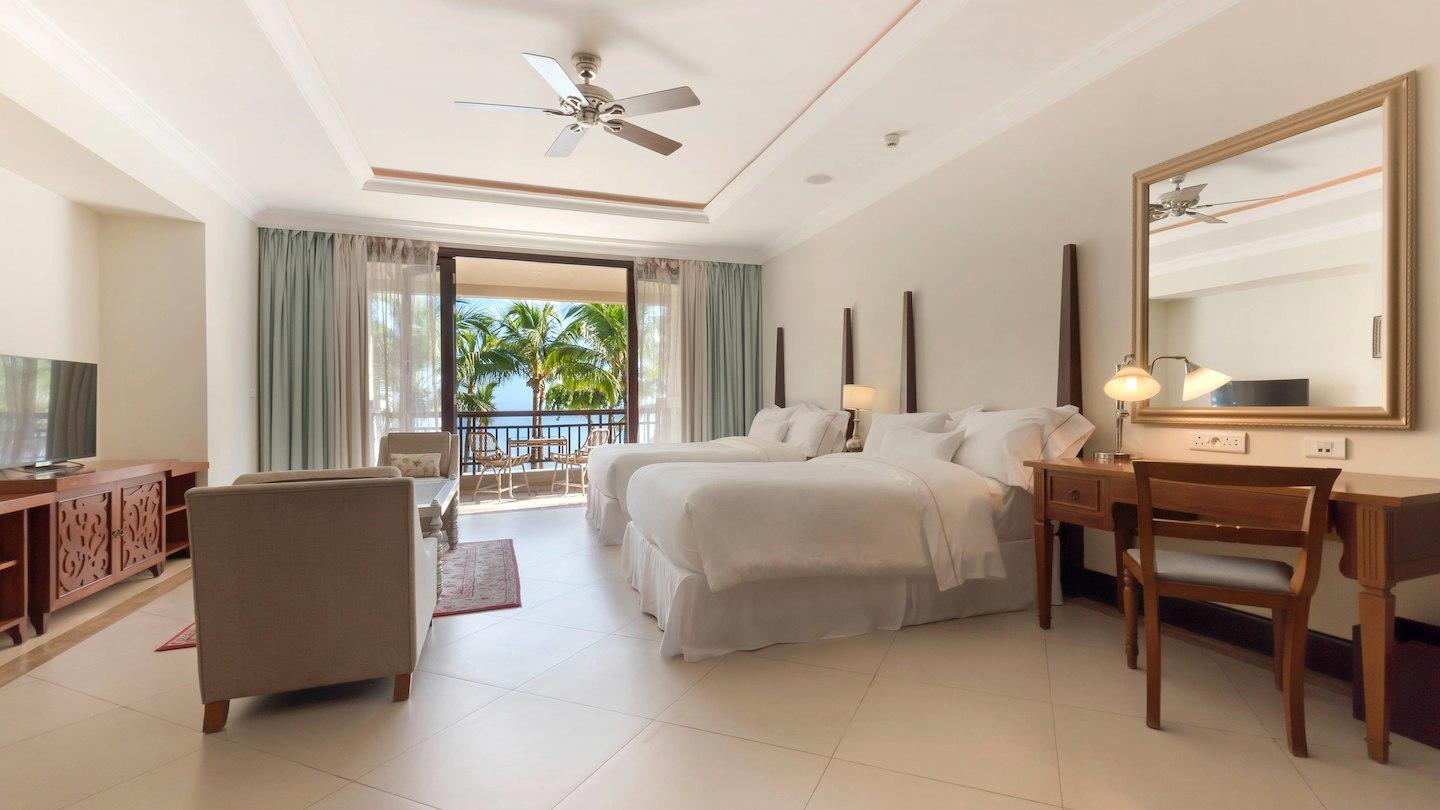 Tall palm trees frame a manicured lawn overlooking the ocean at The Westin Turtle Bay Resort & Spa.