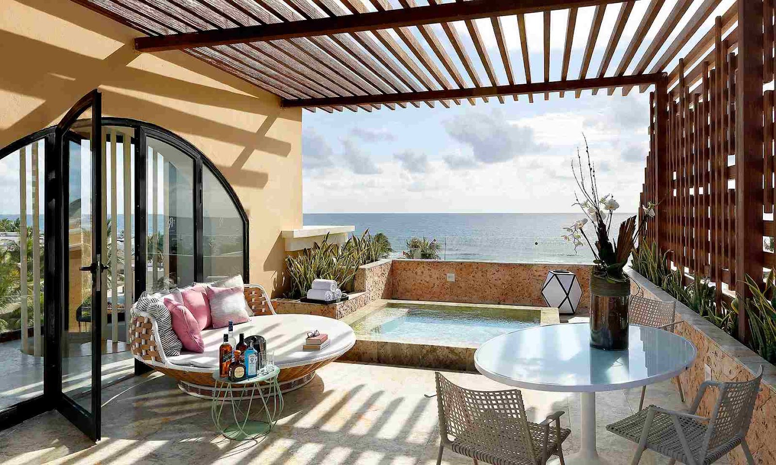 Resort suite with king bed, soaking tub, and balcony overlooking green landscape at TRS Yucatan Hotel.