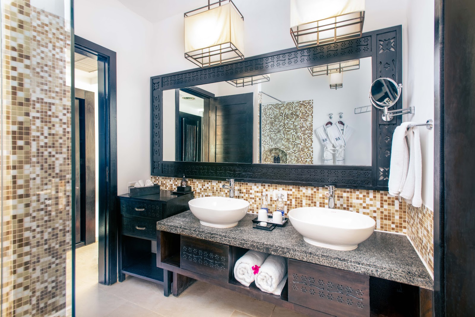 Modern bathroom with two white rectangular sinks, geometric patterned tile accent wall, and walk-in shower at TUI BLUE Bahari Zanzibar.