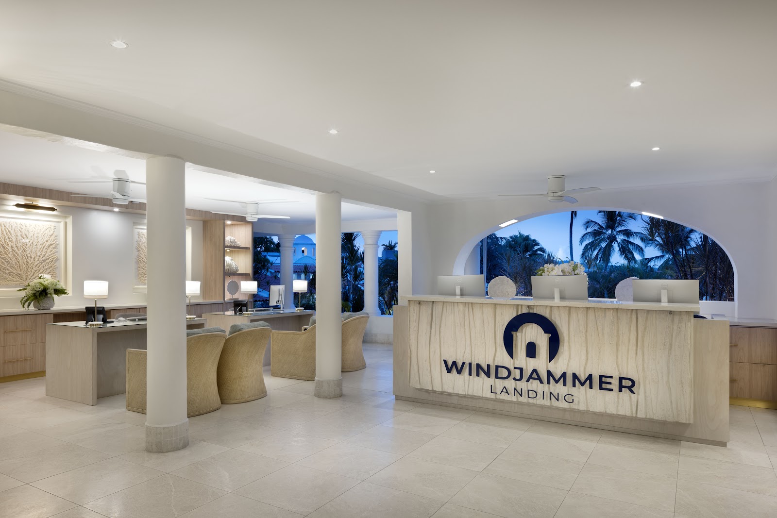 Open-air dining pavilion at Windjammer Landing with woven pendant lights, white columns, and turquoise water views beyond the beach.